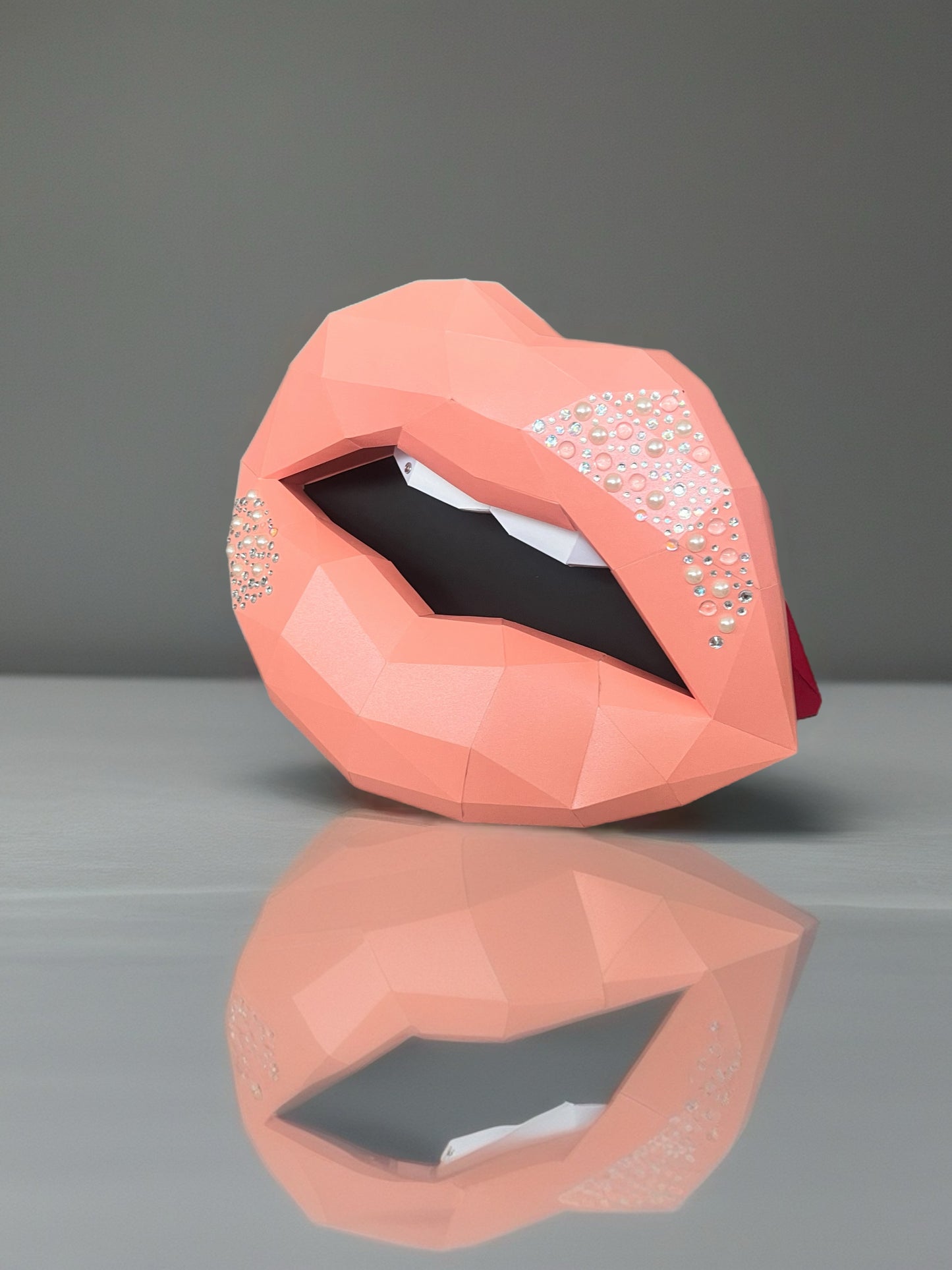 3D figura usana sa kristalima, bočni pogled sa refleksijom na sivoj površini