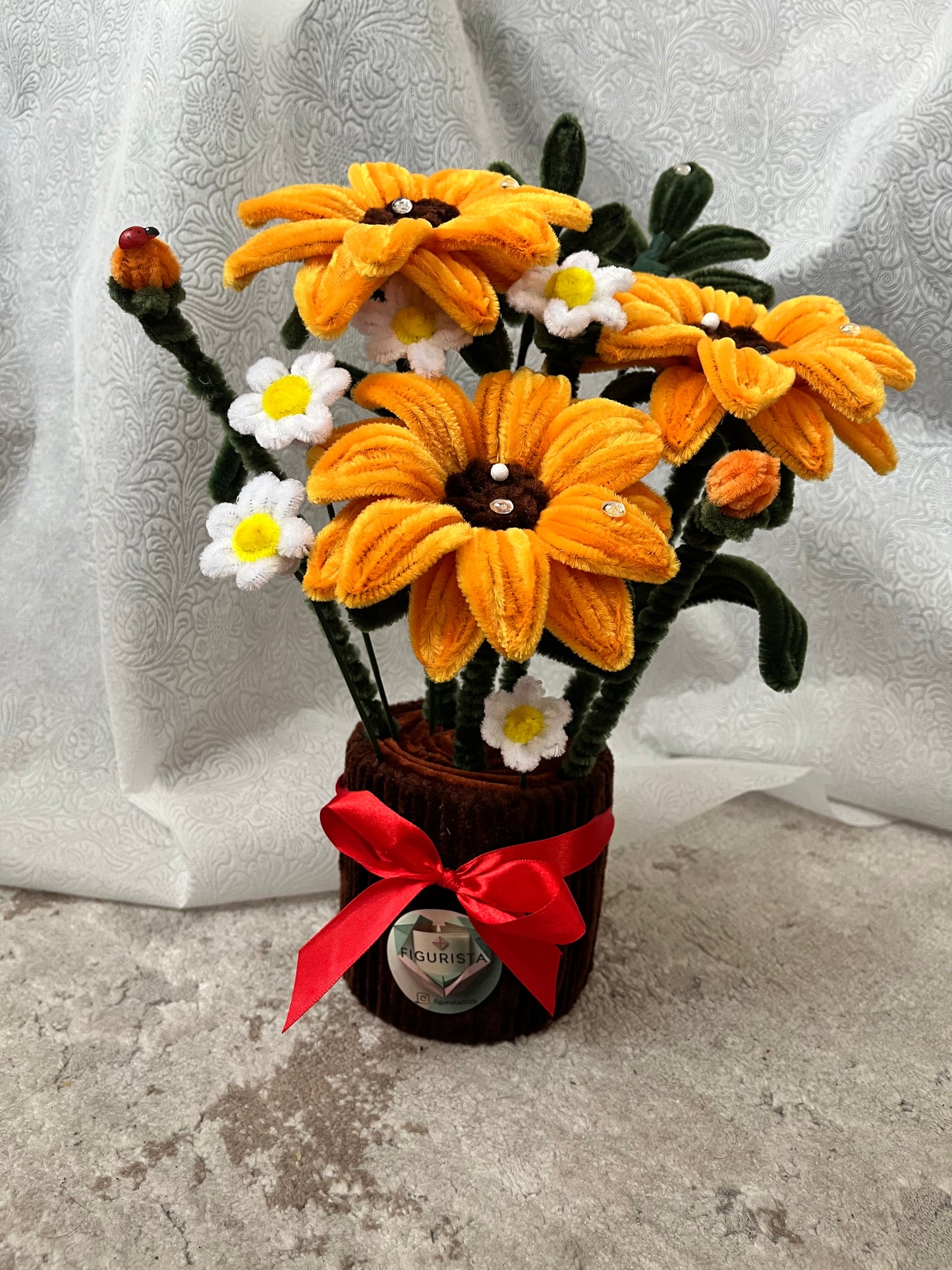 Detalj ručno rađenog plišanog suncokreta sa kristalnim ukrasima i belim margaretama