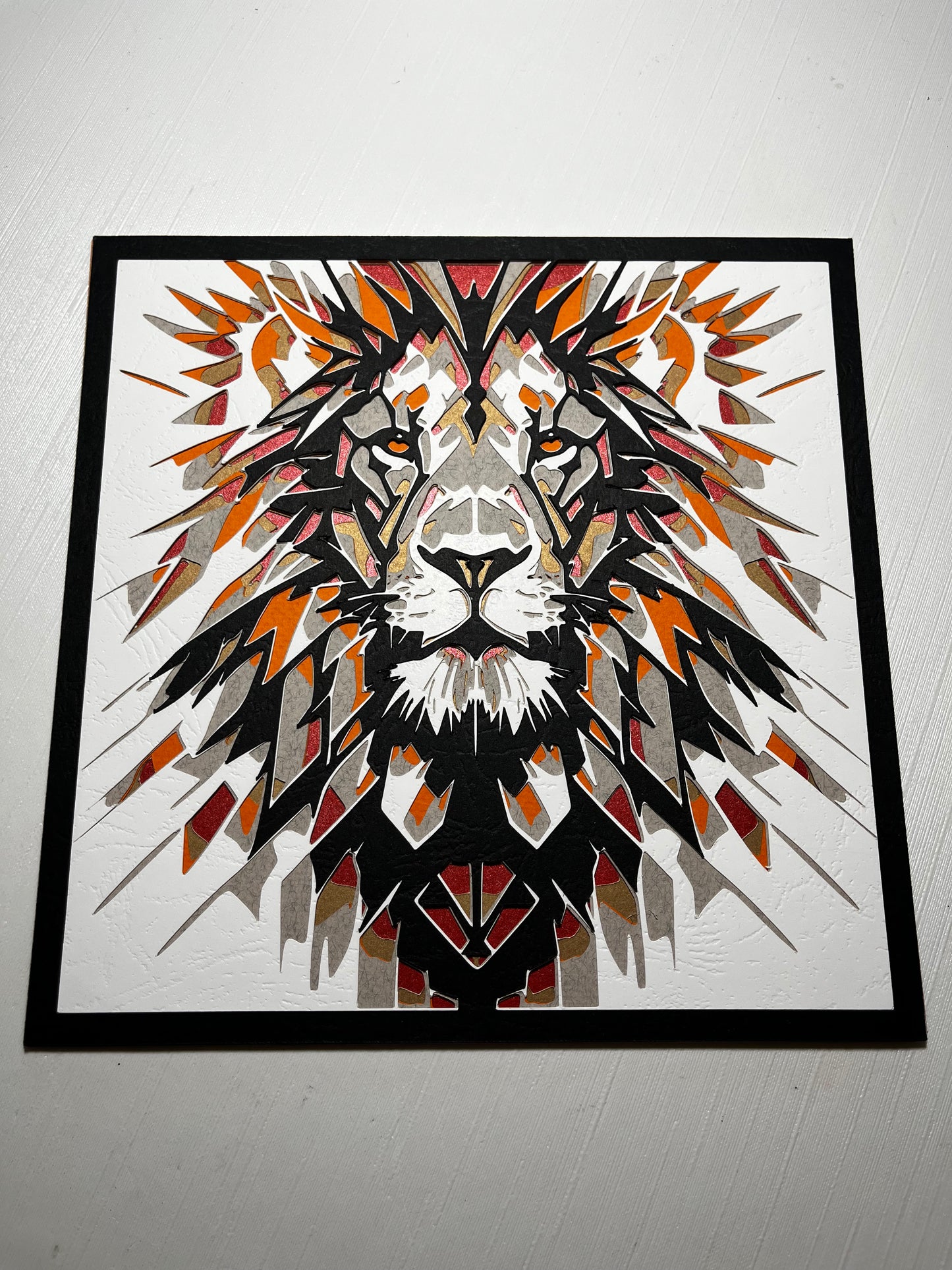 Višeslojna papercut dekoracija lava – geometrijski pop-art portret u crnoj, narandžastoj i crvenoj boji