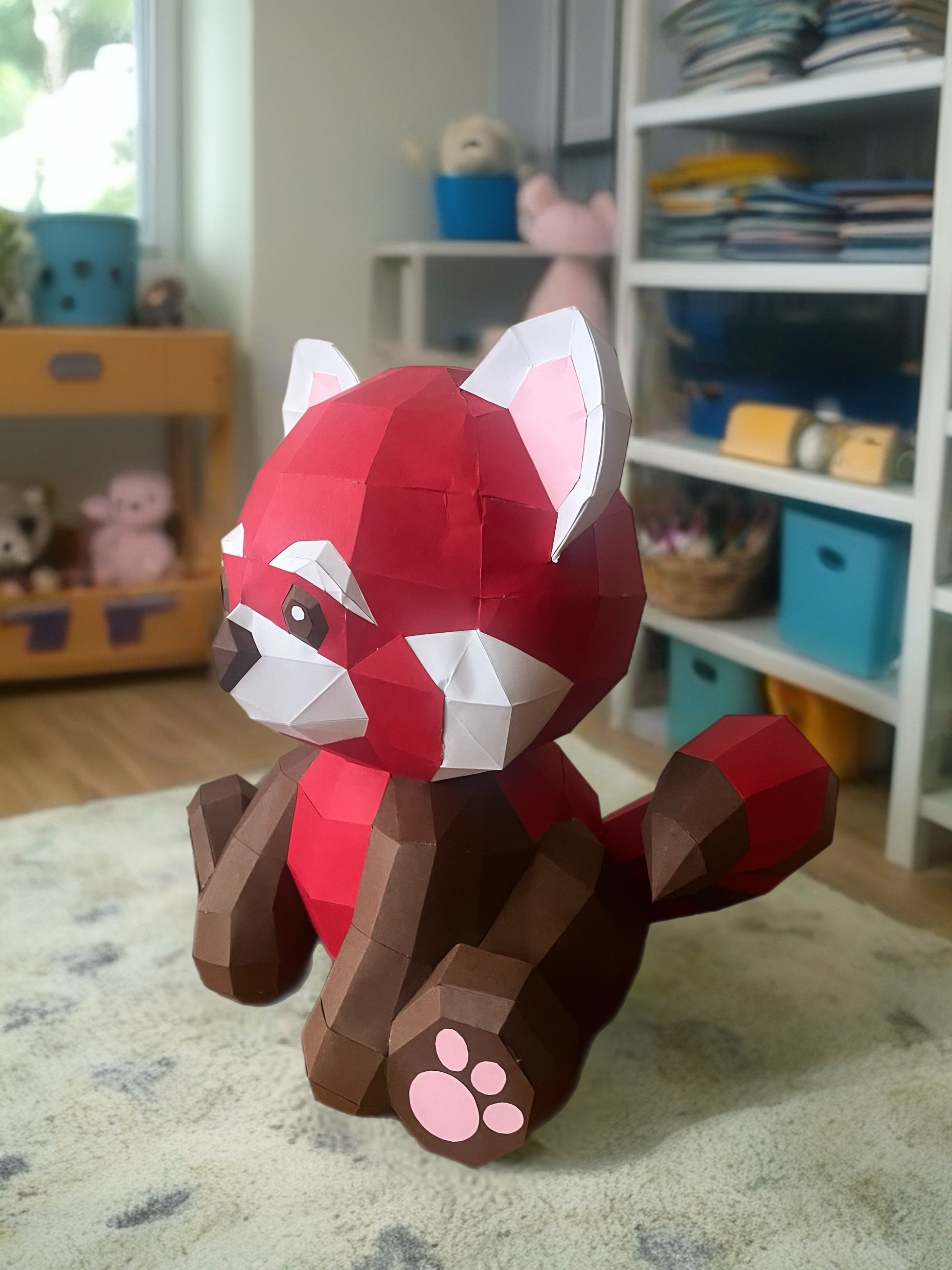 Low poly 3D papercraft skulptura crvene pande u dečijoj sobi, bočni ugao sa repom, police sa igračkama u pozadini