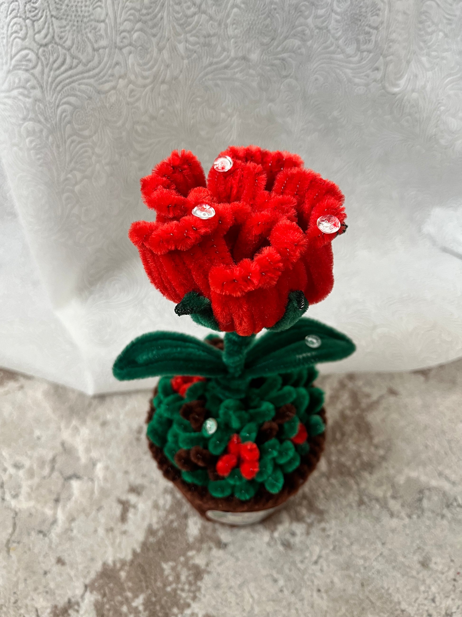 Detalj plišane crvene ruže sa kristalnim ukrasima, pogled odozgo