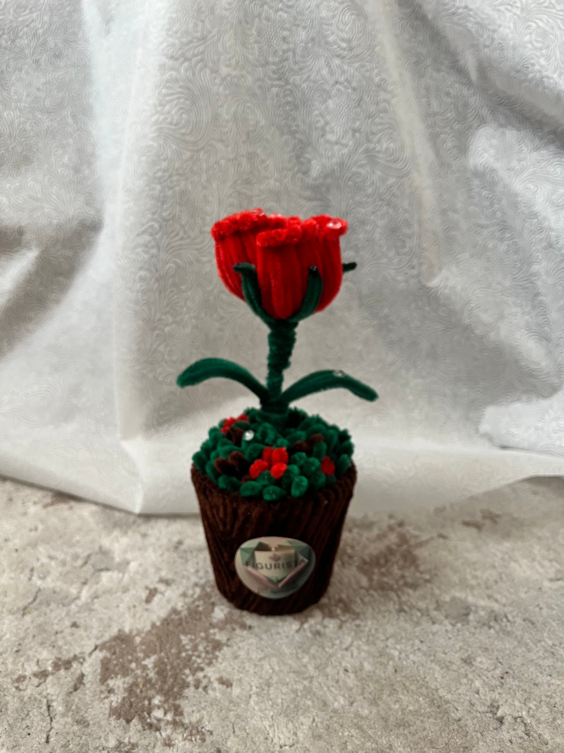 Plišano-žičani buket crvene ruže sa zelenim listovima u dekorativnoj saksiji, bočni pogled