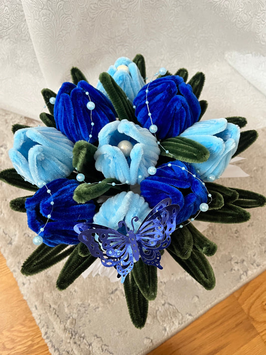 Plišani buket plavih lala u beloj saksiji, pogled odozgo sa leptirom i perlicama