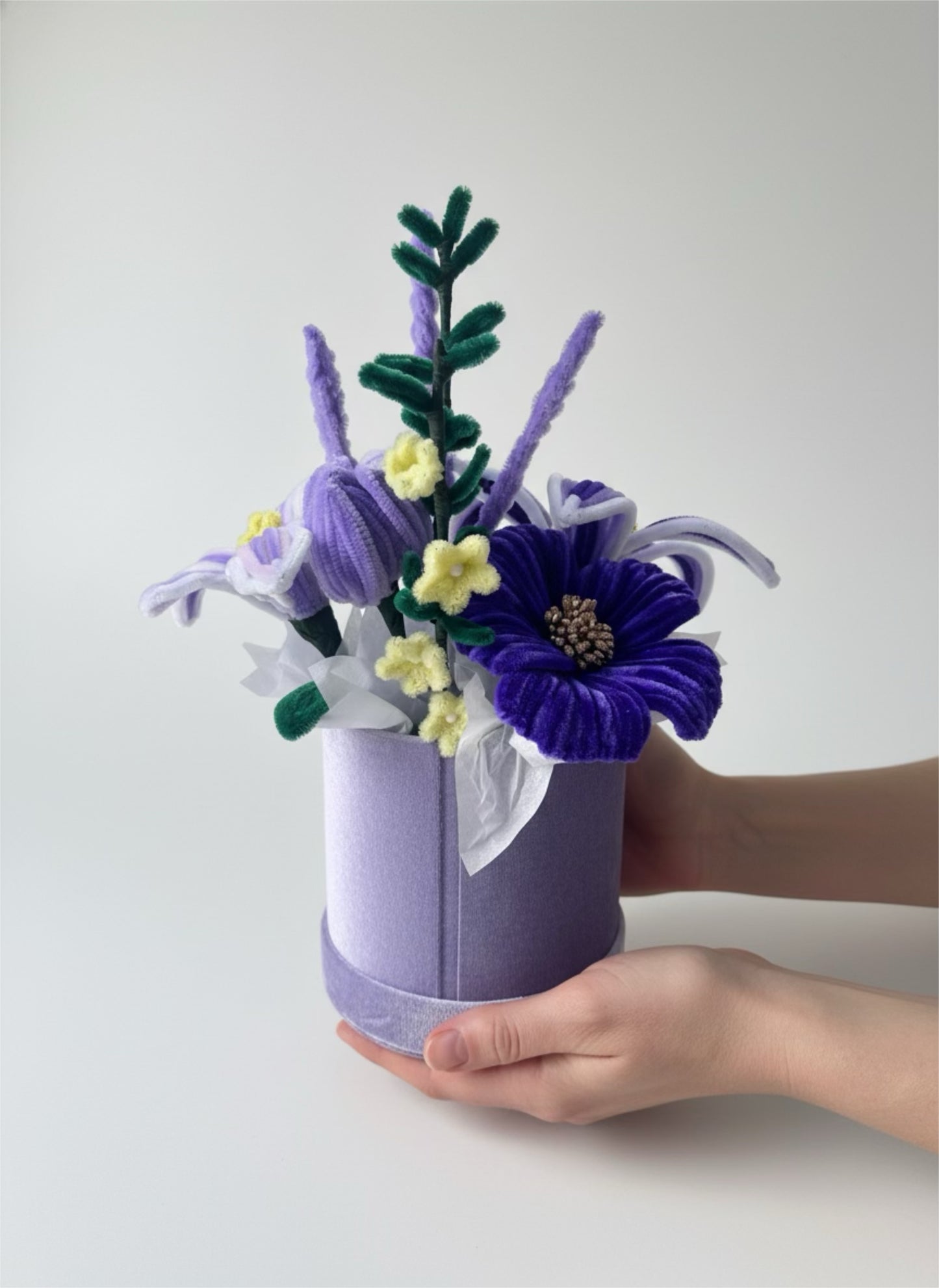 Ručno rađeni plišani buket ljubičastih cvetova u okrugloj lila kutiji sa belom mašnom