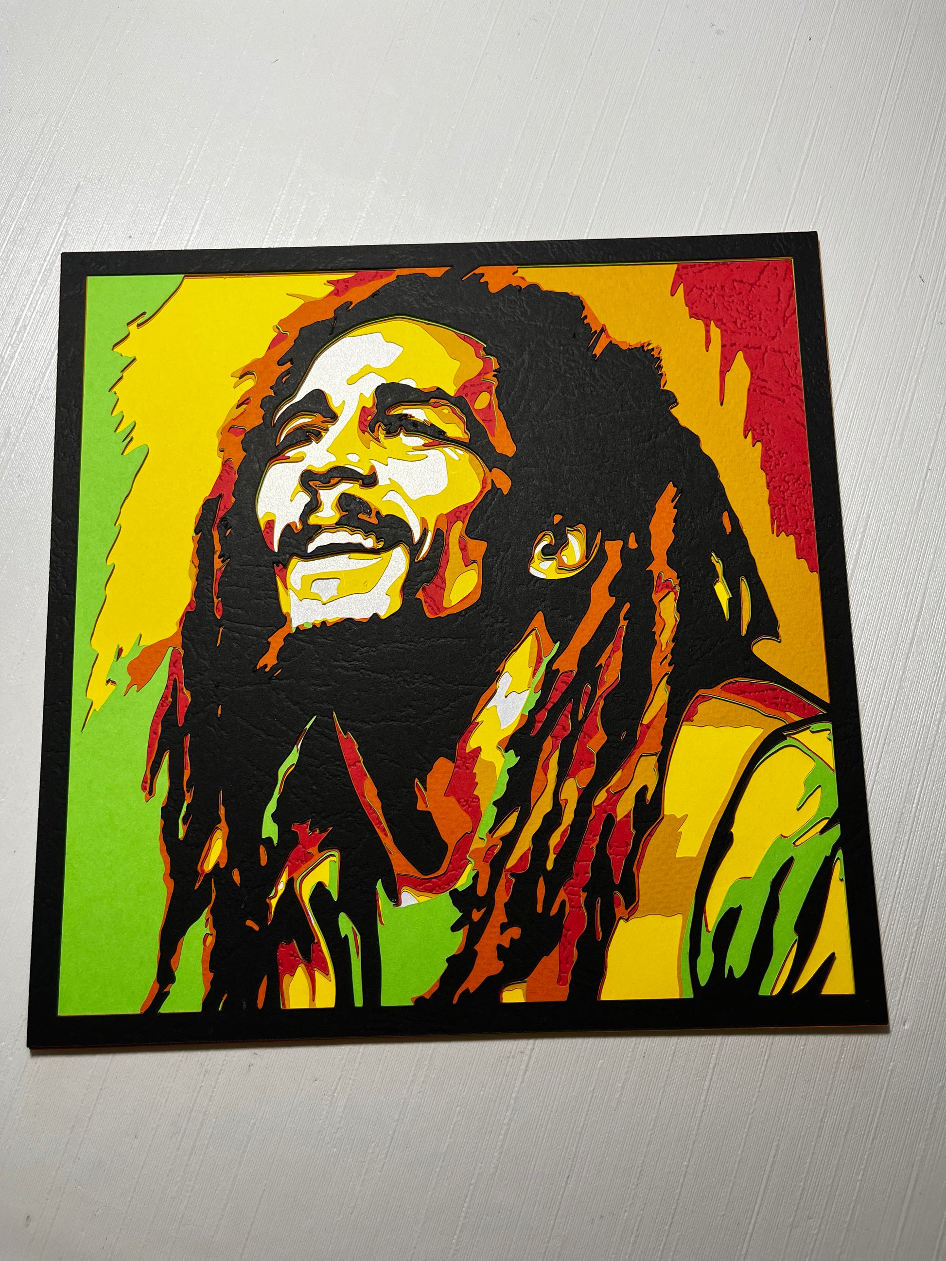 Višeslojna papercut dekoracija Bob Marley – pop-art portret u zelenoj, žutoj i crvenoj boji